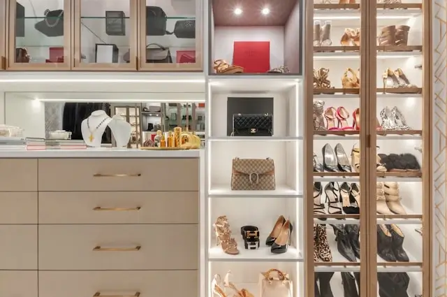 Luxury closet with designer handbags and shoes displayed on illuminated shelves