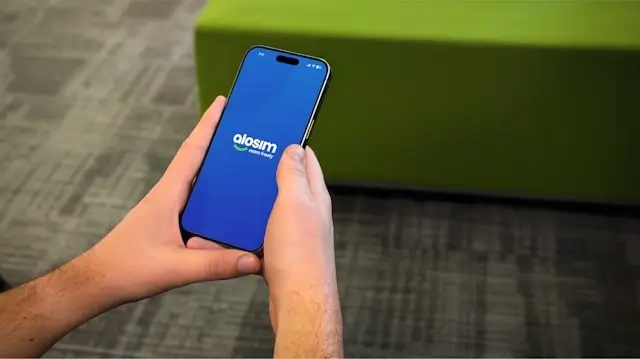 Person holding a smartphone with the Alosim eSIM app open for stress-free travel connectivity