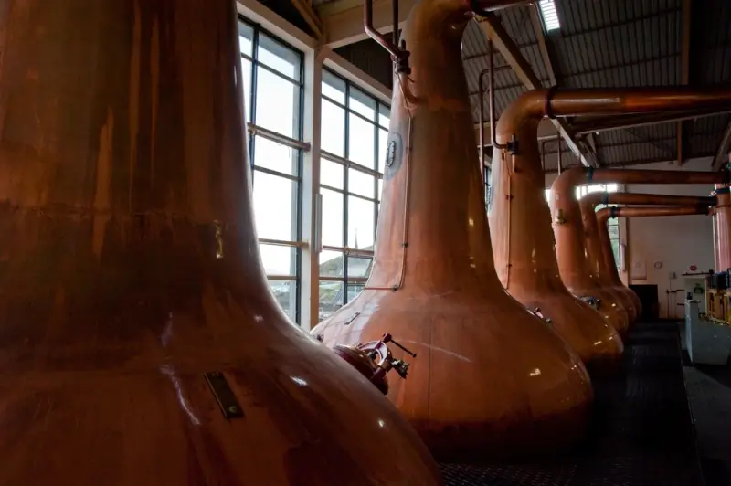 Inside an Islay distillery copper pot stills — a must-visit stop on a whiskey tour in Scotland
