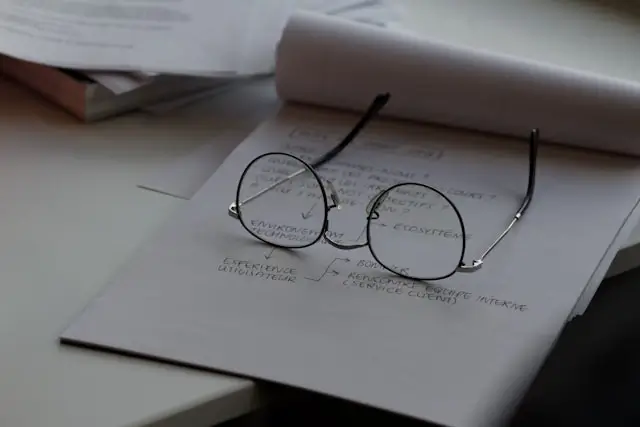 eyeglasses resting on handwritten psychiatric notes and treatment planning documents