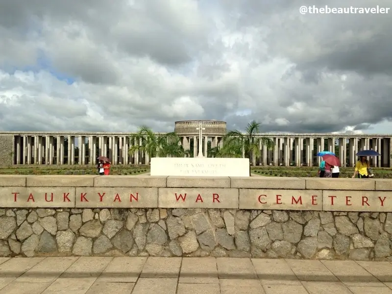 Taukkyan War Cemetery entrance with stone memorial and visitors in Yangon, Myanmar