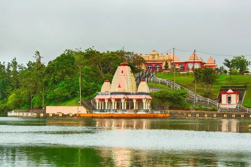 Hindu temple reflected in the sacred crater lake at Ganga Talao Grand Bassin Mauritius on a misty overcast day