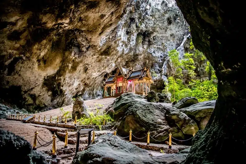 A golden royal pavilion inside Phraya Nakhon Cave in Khao Sam Roi Yot National Park illuminated by natural light