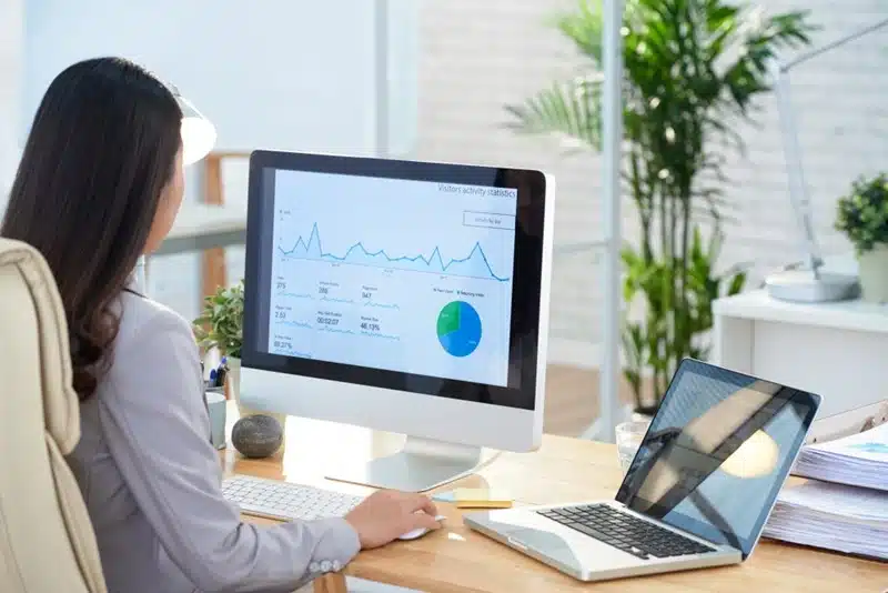 business owner reviewing website traffic and Google Analytics statistics on a desktop monitor