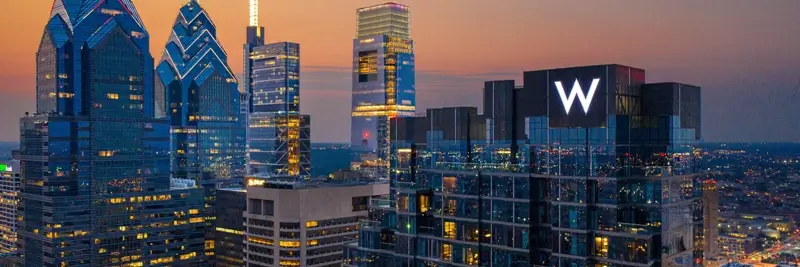 W Hotels illuminated sign against a glowing city skyline at dusk for a girls' trip