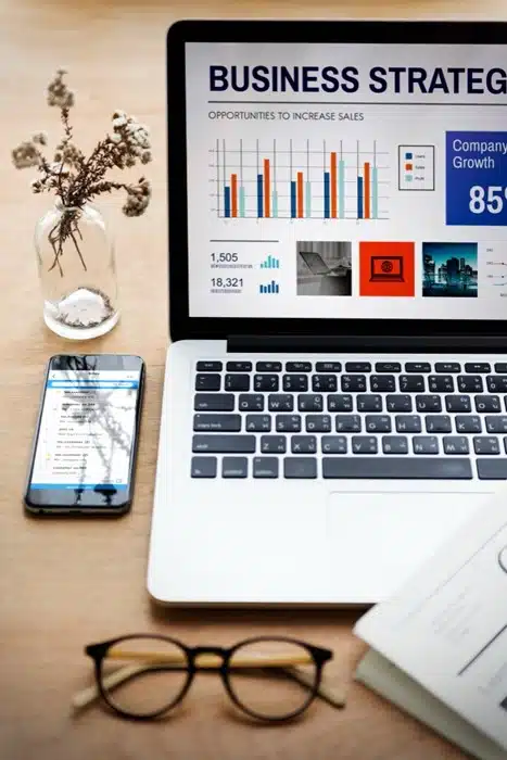 laptop displaying a business strategy dashboard with sales growth data and analytics charts
