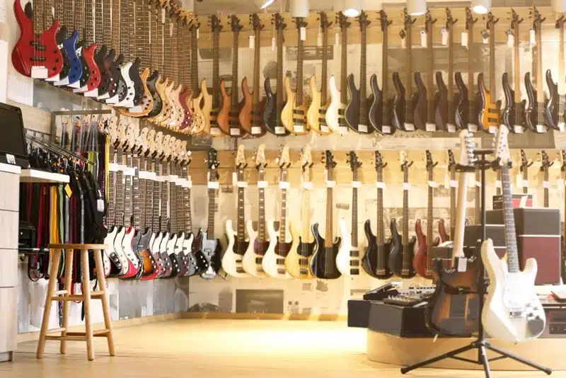 wide selection of guitars displayed on walls inside a music store