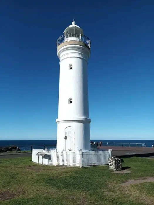 white Kiama lighthouse standing against a clear blue sky overlooking the ocean in NSW Australia