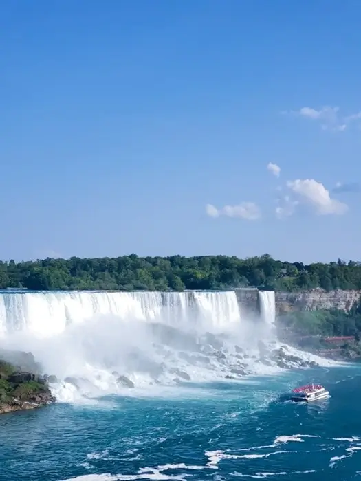 boat cruise approaching the base of Niagara Falls in Canada on a sunny day