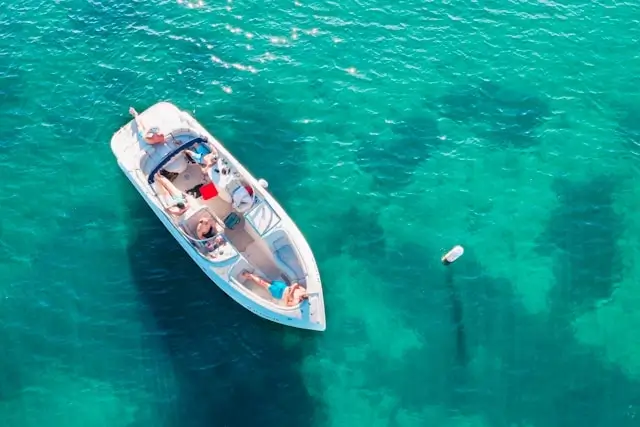 Aerial view of a group of people relaxing on a shared boat in clear turquoise water