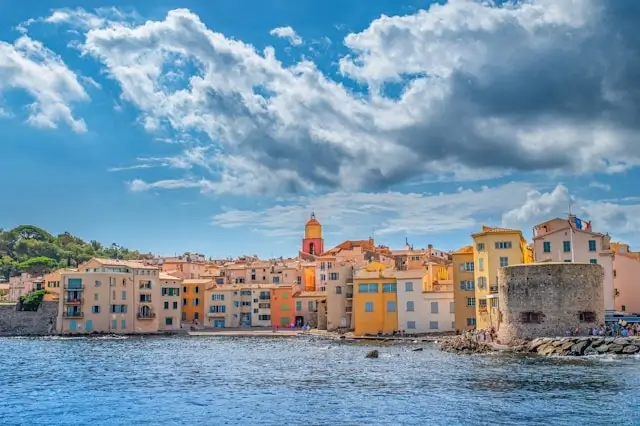 Colorful waterfront buildings and church tower of St. Tropez on the French Riviera seen from the sea