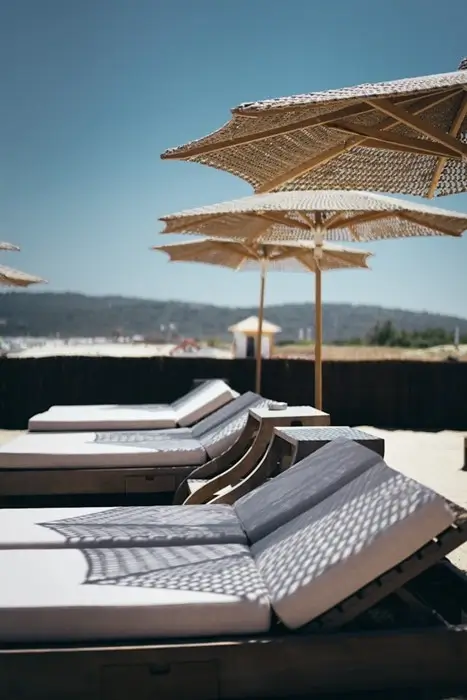 Private sunbeds and woven parasols on a luxury villa terrace offering privacy in St. Tropez