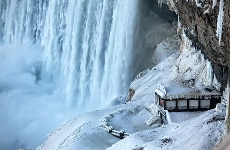 snow and ice formations covering the observation deck and cliff face behind Horseshoe Falls in winter