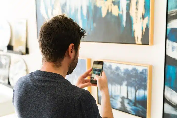 man taking photo of painting during virtual museum tour