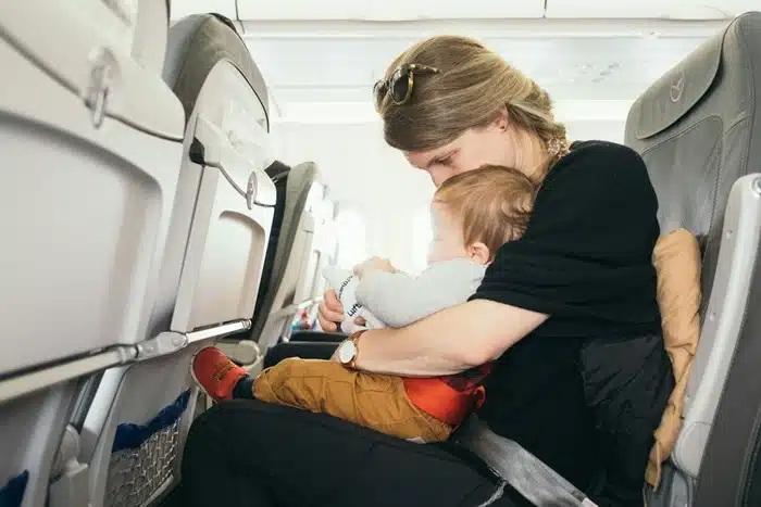 mother cradling a baby while traveling on an airplane