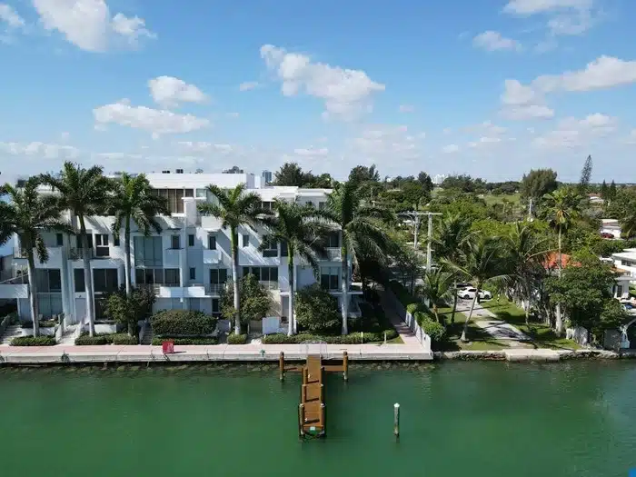 Aerial view of a waterfront property in Florida with a private dock extending into a green canal