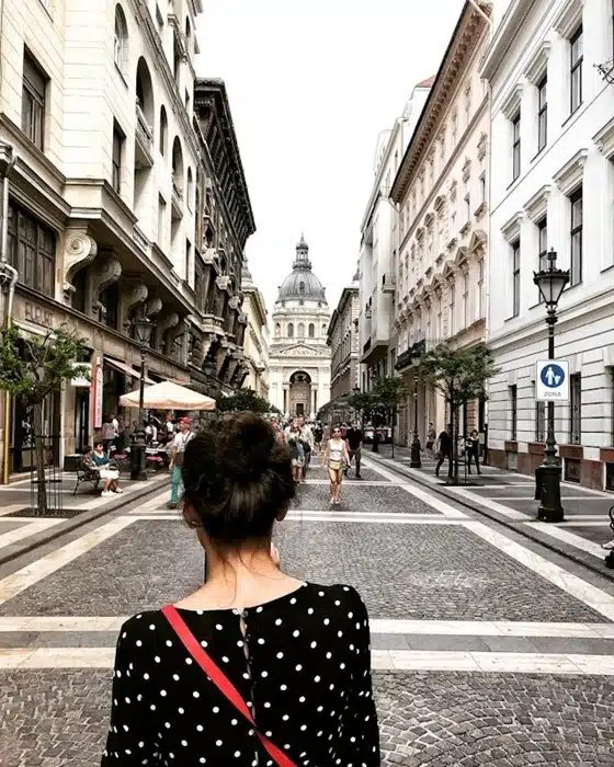 Woman seen from behind on a pedestrian street in Budapest with St. Stephen's Basilica framed at the end