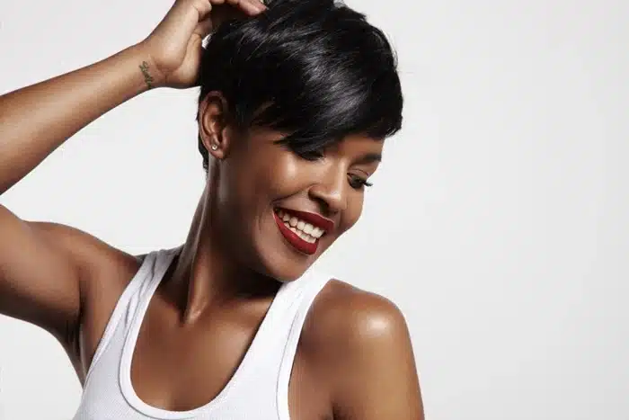 Black woman smiling wearing a short bob wig with side-swept bangs