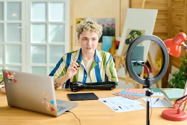 young creator talking on camera using a ring light and laptop.