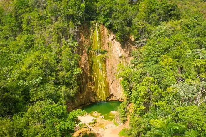 Lush jungle surrounds the Salto El Limón waterfall and natural pool in the Dominican Republic mountains