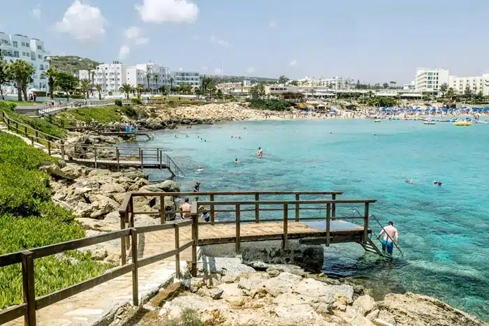 Fig Tree Bay beach in Protaras with calm clear water and hotels in the background