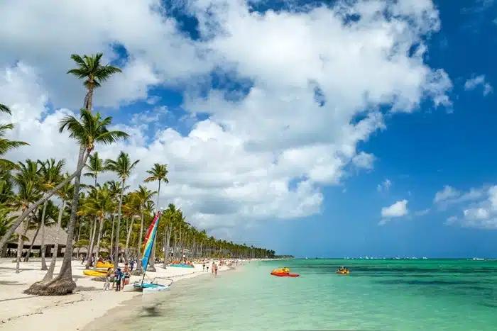 Palm-lined luxury resort beach in Punta Cana with turquoise water, white sand, and water sports equipment