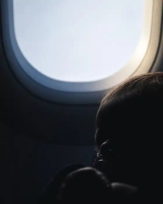 silhouette of a newborn by an airplane window while traveling