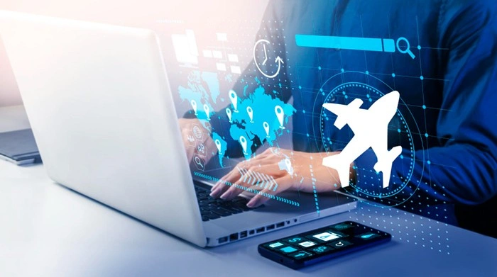 Person typing on a laptop with a digital world map and airplane graphic, managing a business travel itinerary online