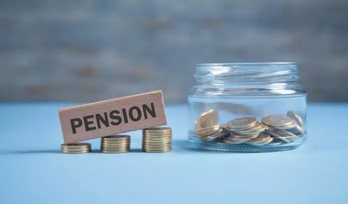 pension sign with stacked coins and a glass jar representing retirement savings planning for expats
