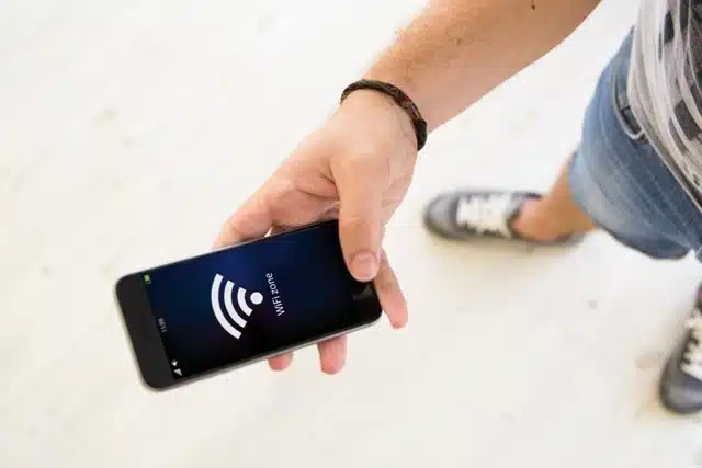 person holding a smartphone displaying a WiFi zone connection signal