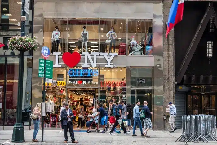 I Love NY gifts and luggage storage in New York storefront with tourists walking by on a busy city street