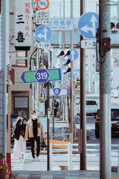 couple walking along a busy Japanese street surrounded by road signs and city buildings
