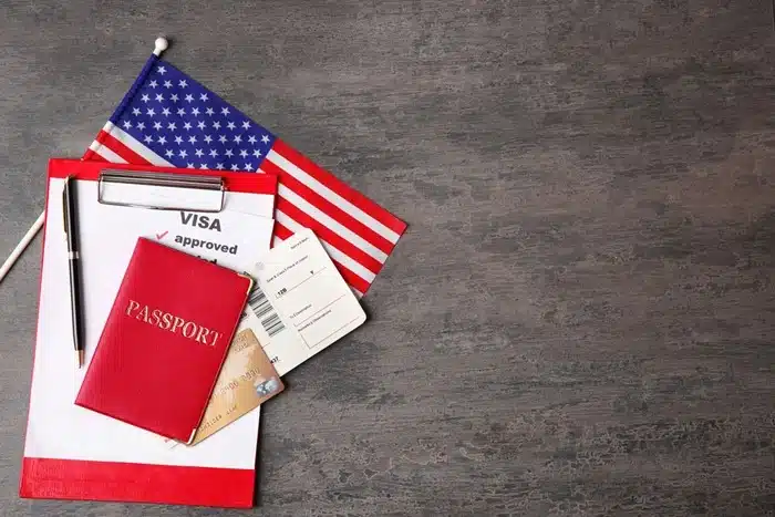 US visa approval document, passport, flight tickets, and American flag for students studying abroad