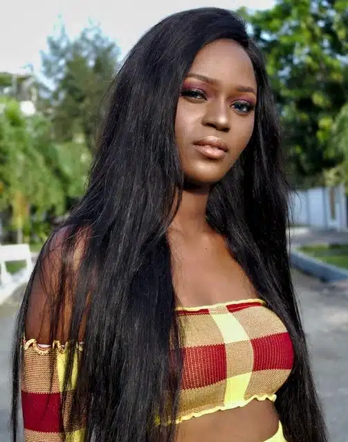 Woman wearing a long kinky straight human hair wig with a natural, sleek finish
