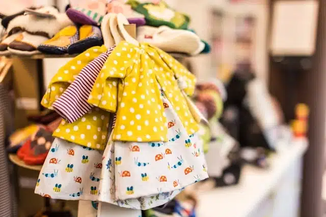 Colorful baby clothes displayed on a rack in a children's shop