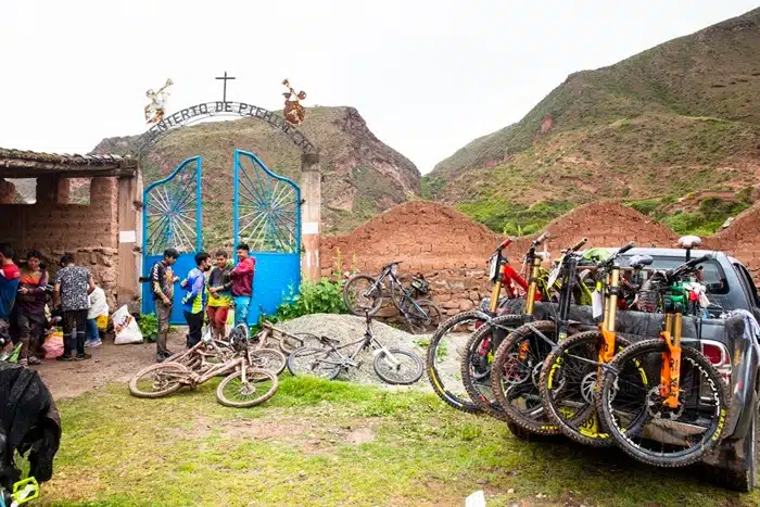 Cyclists and mountain bikes resting near a rural Andean village before a ride