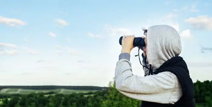 A birding enthusiast scanning the landscape with binoculars at one of the best birding destinations in Eastern Europe