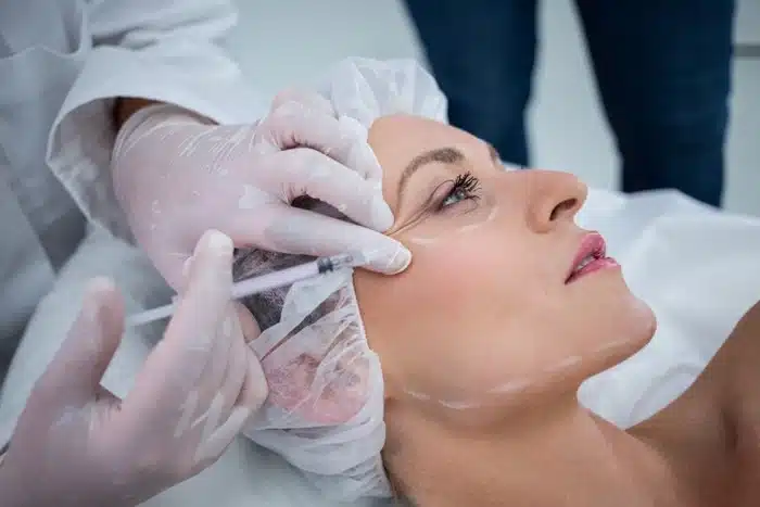a woman receiving a botox injection at an aesthetic treatment clinic