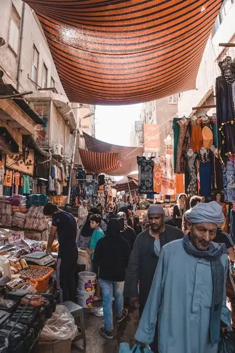 Crowded Cairo bazaar with colorful stalls and locals in traditional dress in Egypt