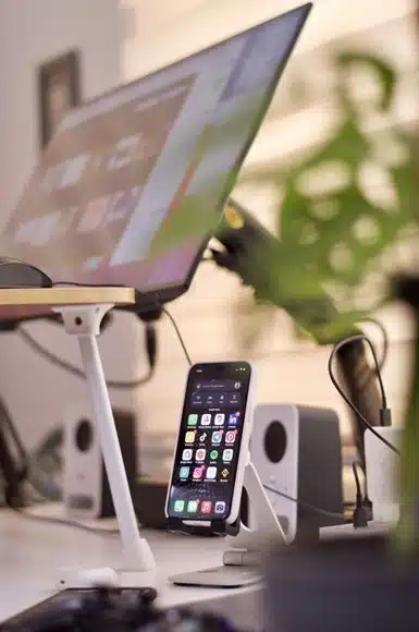 Laptop, smartphone stand, and speakers arranged on a compact student desk setup