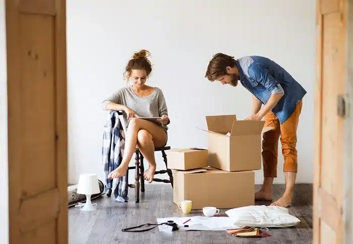Couple unpacking moving boxes together, learning how to adjust life after a major change