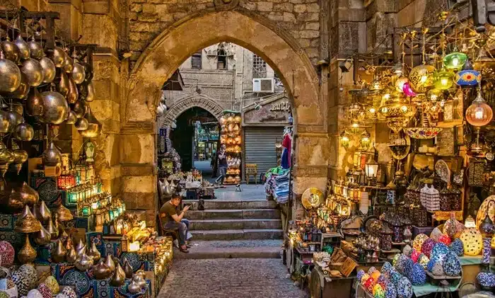 Ancient stone archway of Khan el-Khalili market in Cairo Egypt adorned with hanging lanterns and handcrafted goods