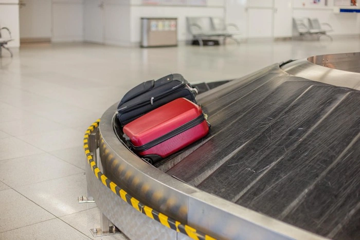 Unclaimed luggage on an airport baggage carousel, representing the risk of lost or stolen belongings when traveling uninsured
