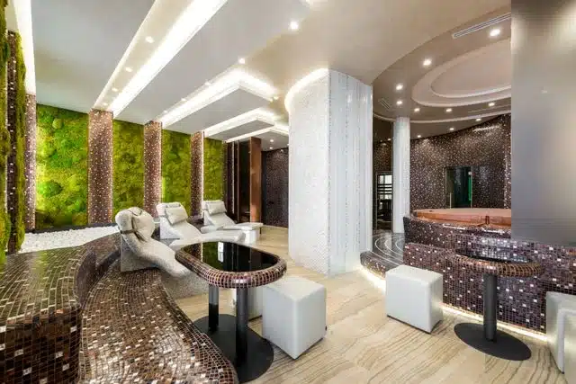 Interior lounge area of a luxury wellness business with mosaic accents and a living moss wall