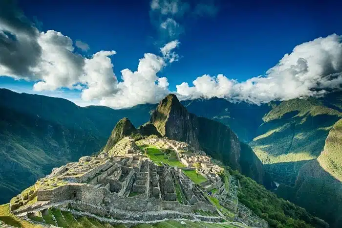 Wide panorama of the Inca citadel of Machu Picchu nestled between green Andean peaks