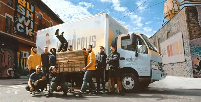 Team of movers posing in front of a moving truck in Bushwick, NYC