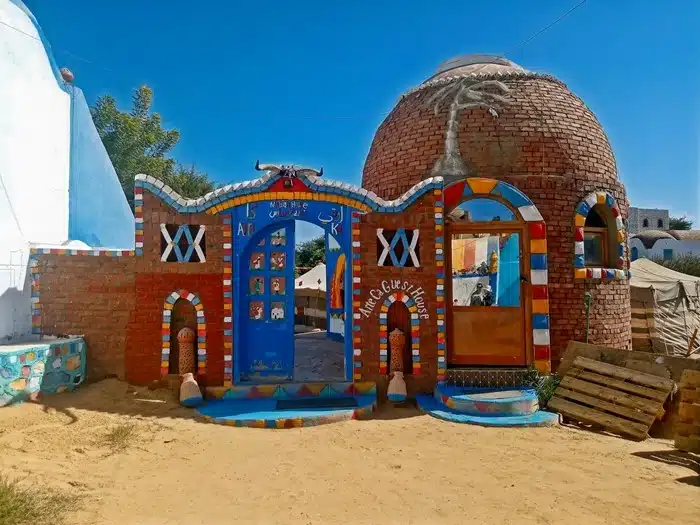 Colorful Nubian village guesthouse with vibrant painted brick architecture in Aswan Egypt