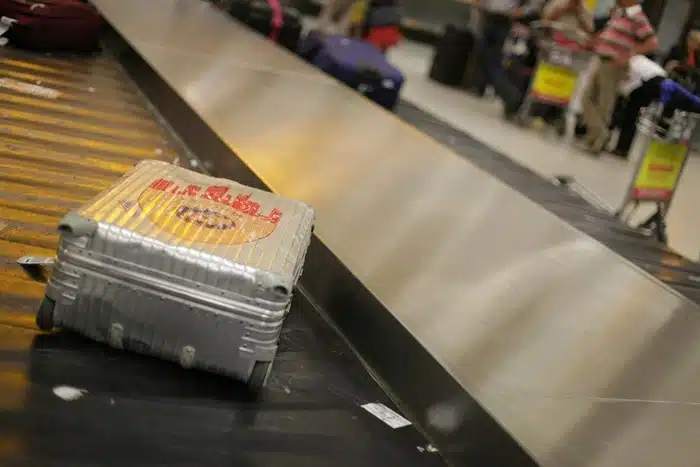 A hard-shell suitcase on an airport baggage claim conveyor belt