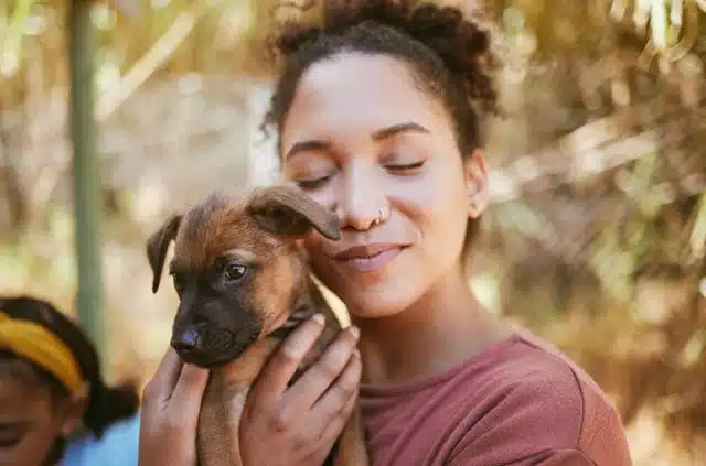 Woman holding and bonding with her newly adopted puppy outdoors