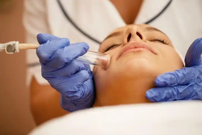 premium beauty treatments for travelers — a woman getting a professional facial treatment at a clinic